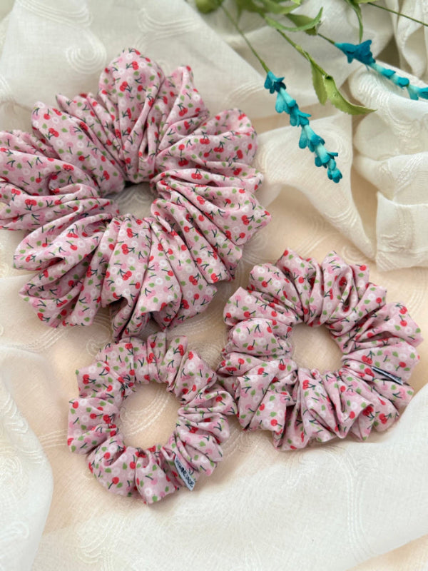 Amy scrunchie in pink cherry print made from 93% polyester and 7% elastane, perfect for short or fine hair with a soft, stylish hold.