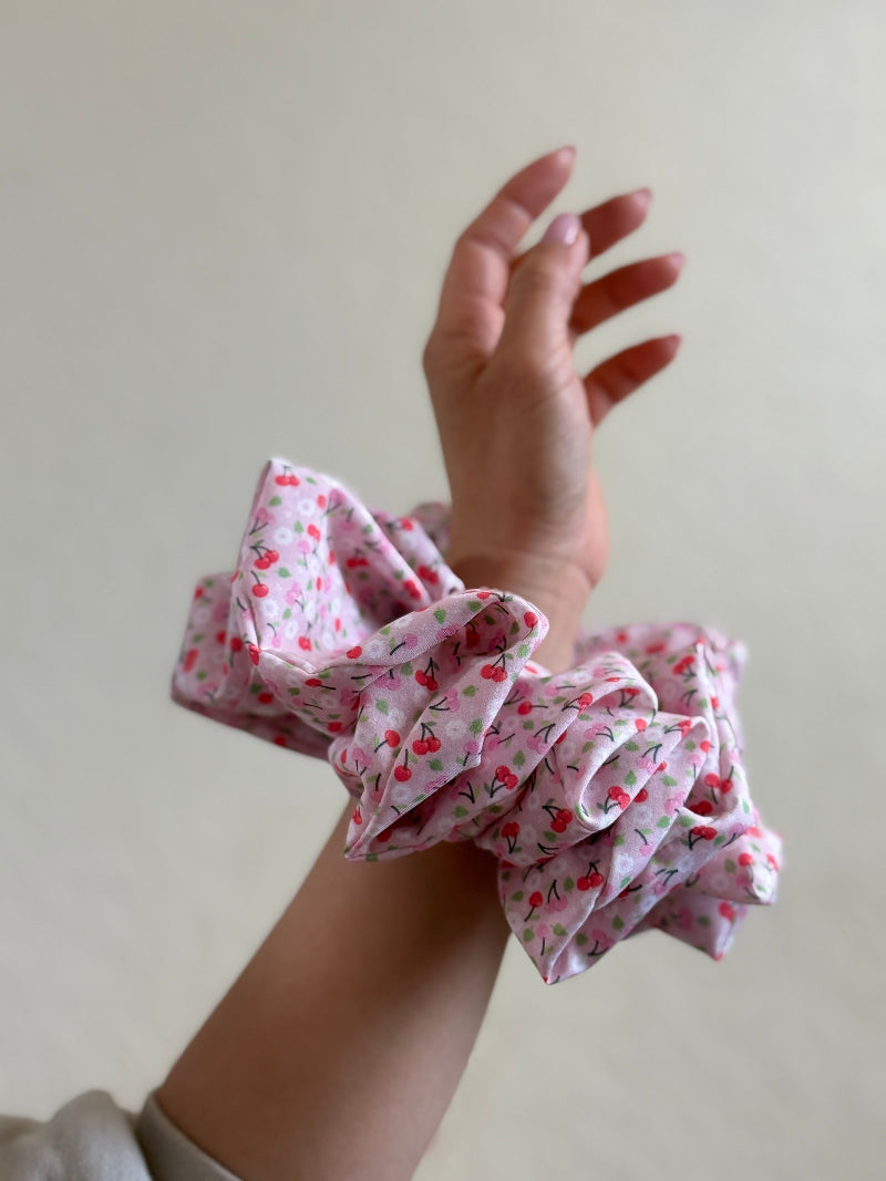 Amy jumbo scrunchie with a pink cherry print, made from soft fabric and designed for thick or long hair with a gentle, secure hold.