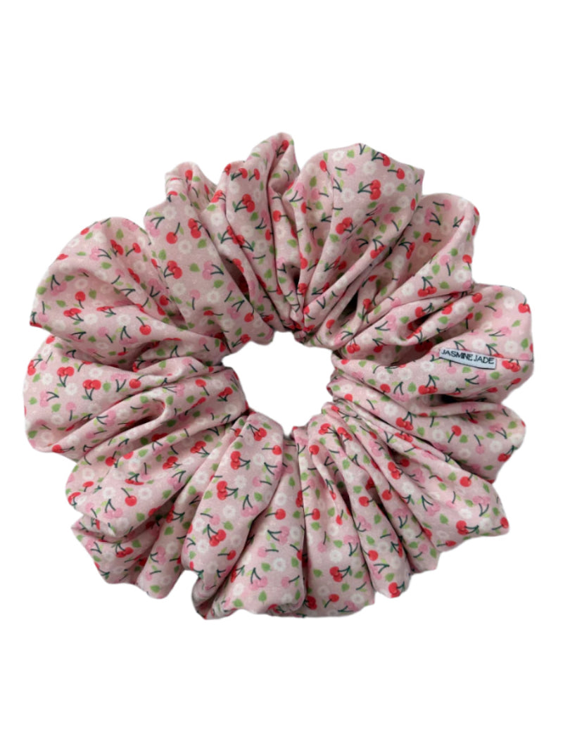 Amy jumbo scrunchie with a pink cherry print, made from soft fabric and designed for thick or long hair with a gentle, secure hold.