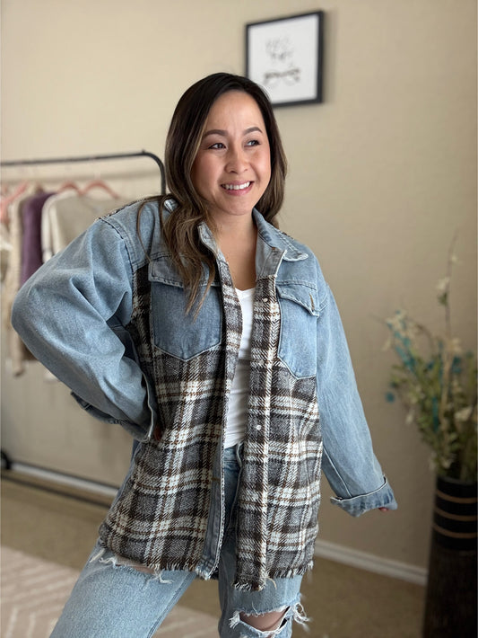 Front view of a woman wearing a denim jacket with plaid contrast, featuring a relaxed fit and button-down front.