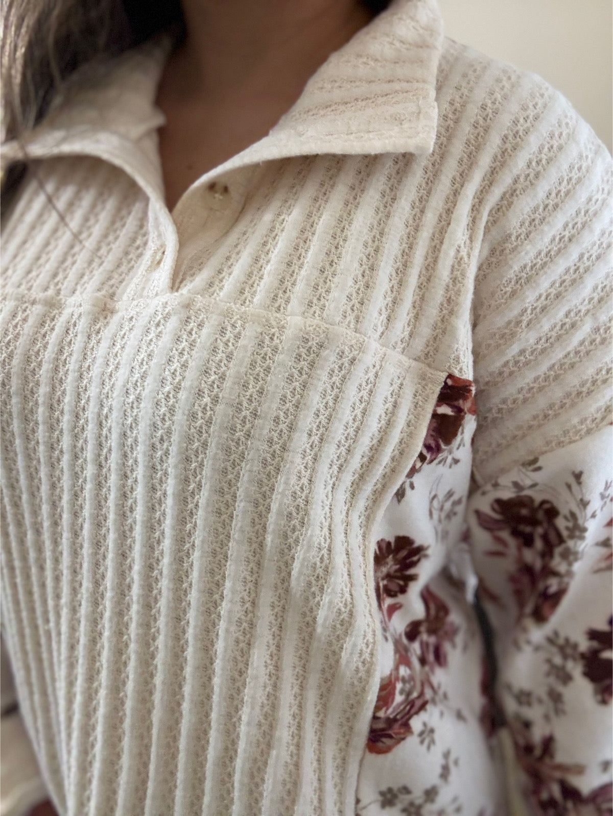 close up view of the Lela Floral Drop Shoulder Brushed Knit Top with pockets, featuring a soft floral print and relaxed silhouette