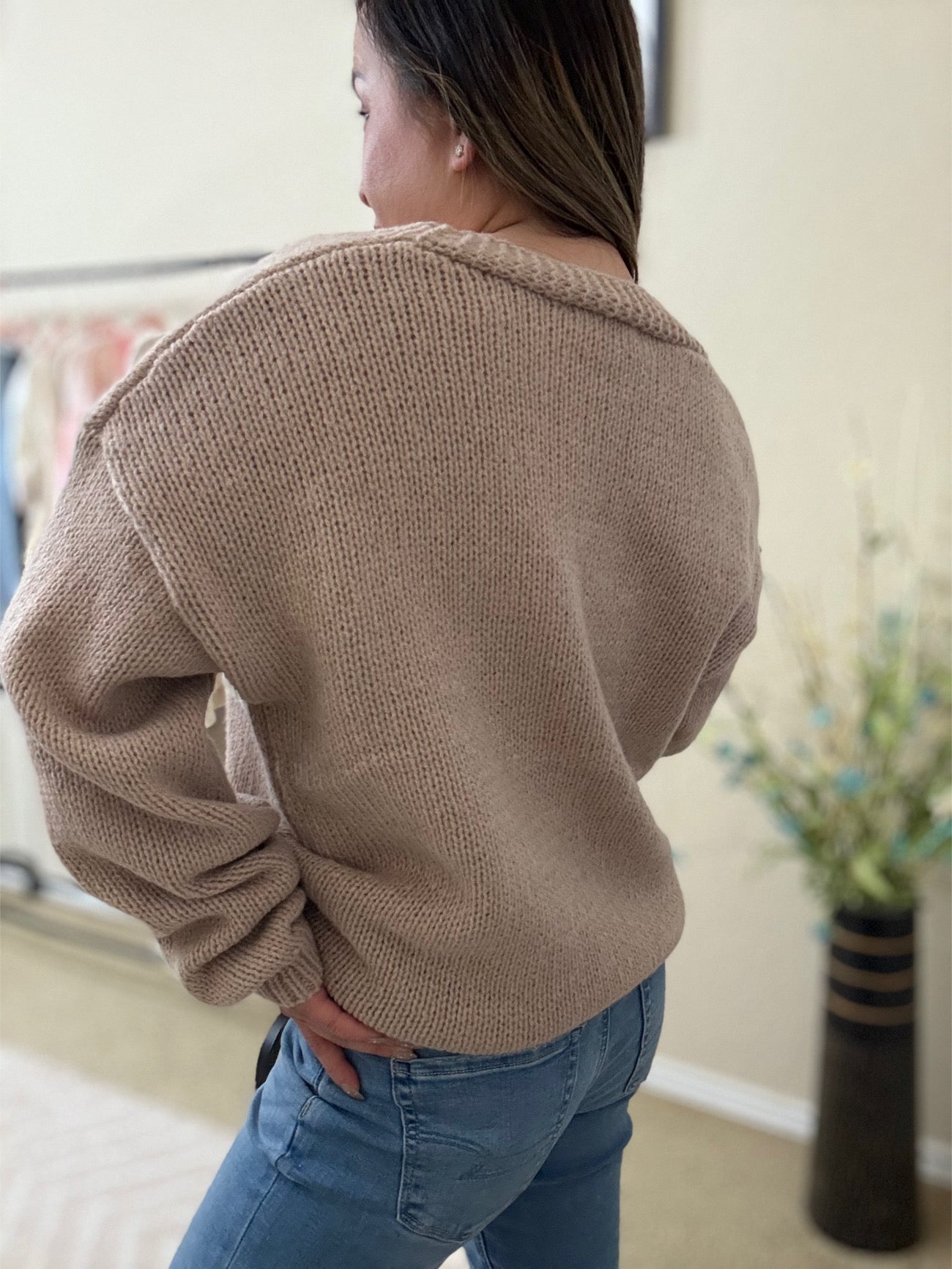 back view of the Lili Flower Cardigan, a beige knit sweater made from 100% polyester, featuring white 3D floral appliqués and a relaxed fit