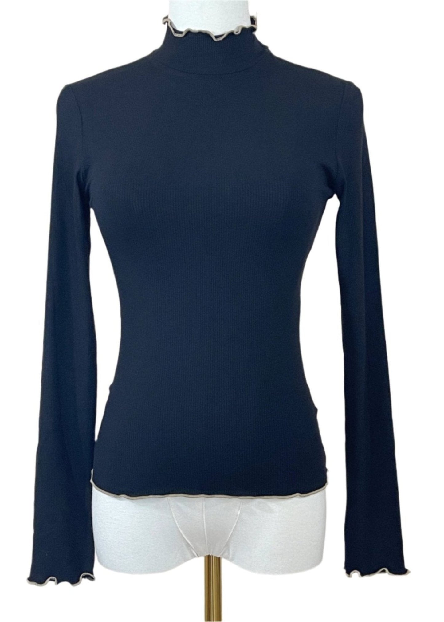 Front view of a black ribbed mock neck top with long sleeves, ruffle details on the neckline, and hem.