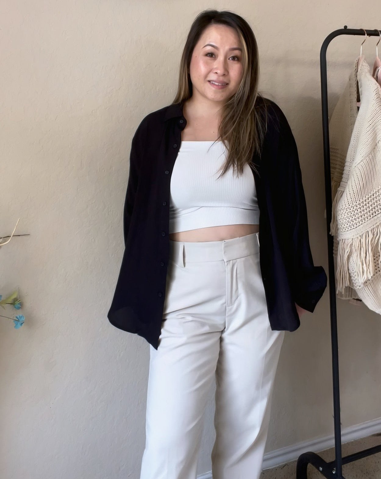 Front view of a woman wearing a black oversized button-down shirt featuring a relaxed fit and lightweight fabric.