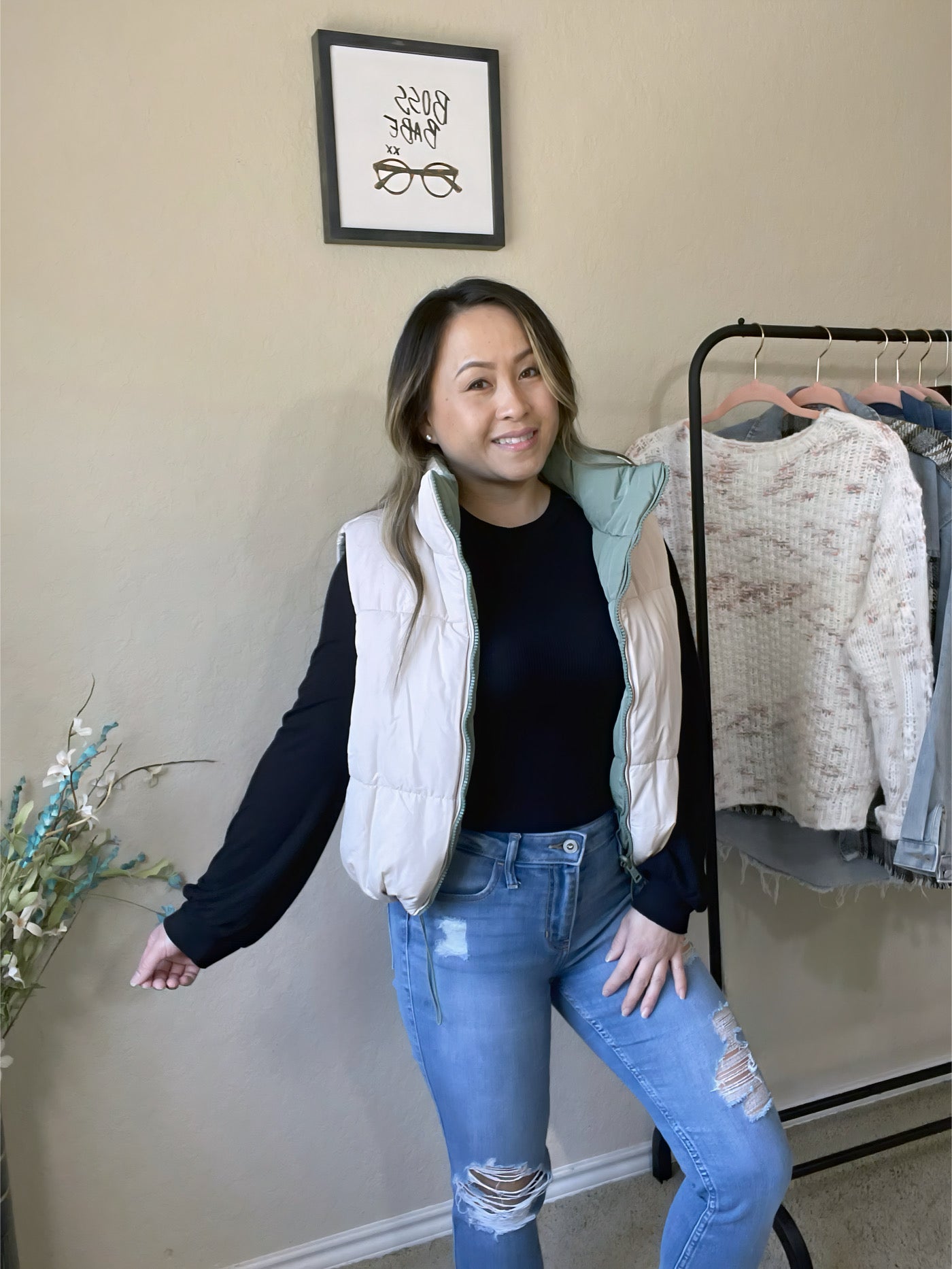 Woman wearing a reversible woven vest paired with a black top and ripped jeans, styled with casual elegance.